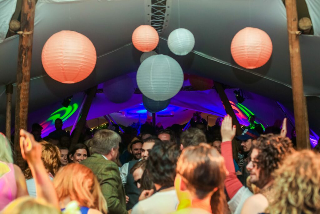 People partying at festival in tipi at night time