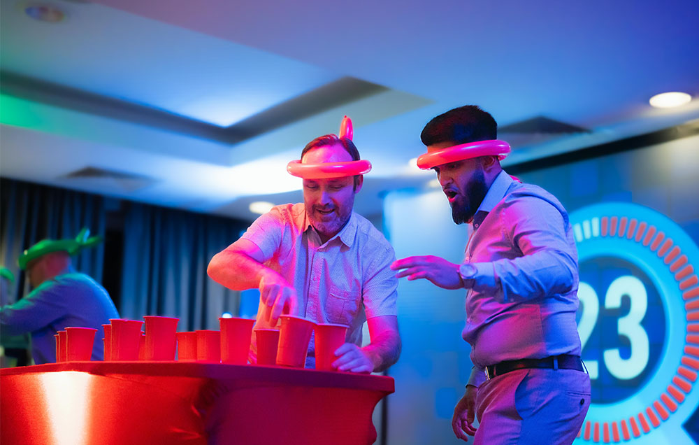 Men working together to flip cups.