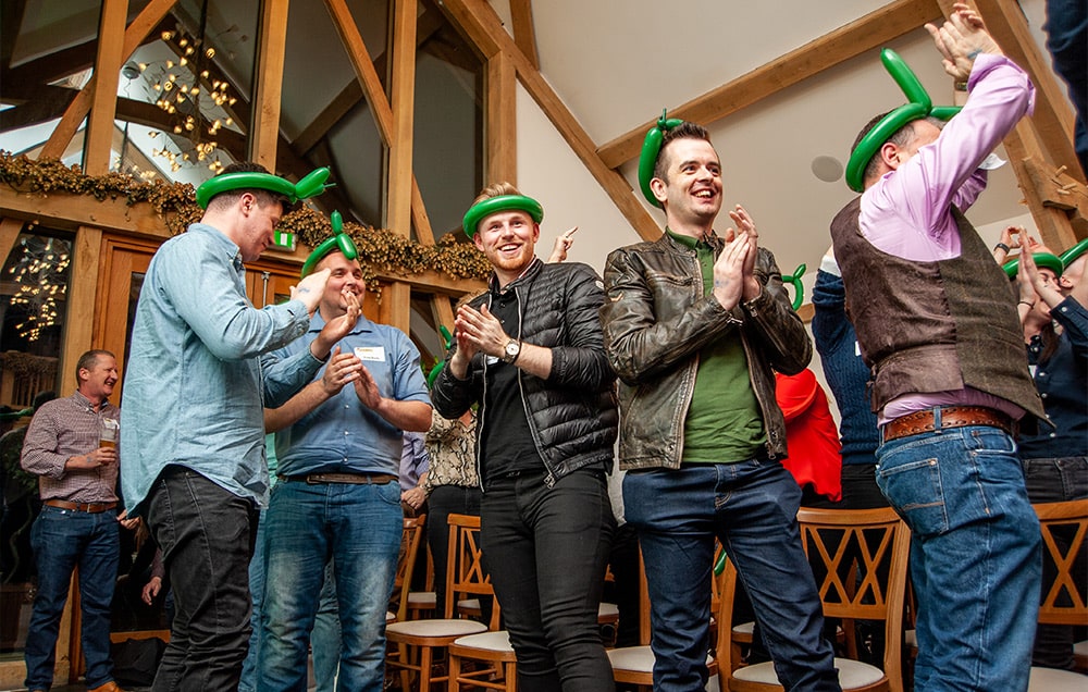 Team cheering wearing green balloon hats