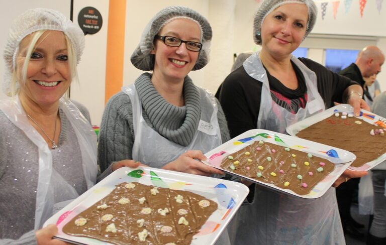 People posing with tray of chocolate