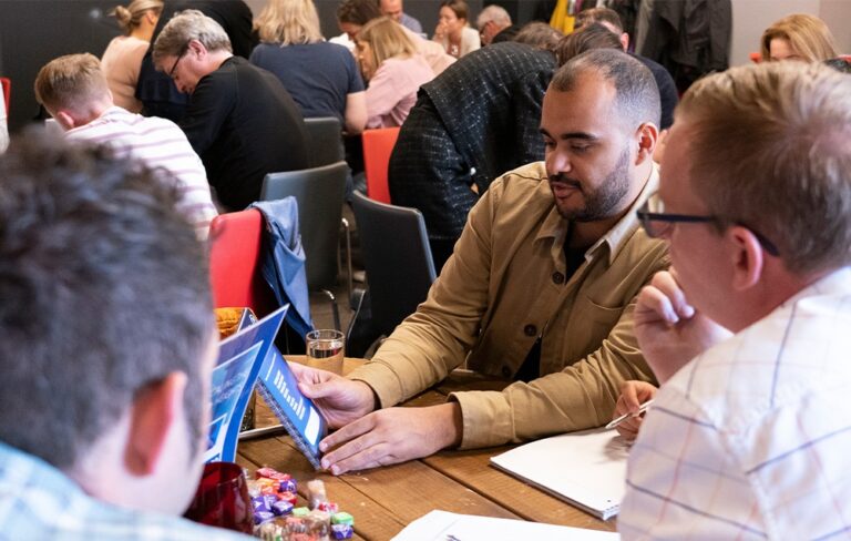 People sitting down at table discussing answers