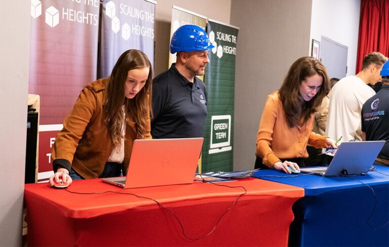 People behind a desk on laptop