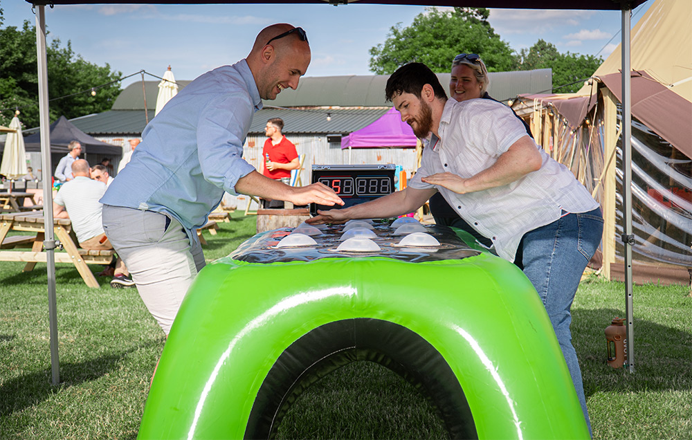 Two people outdoors competing on inflatable game
