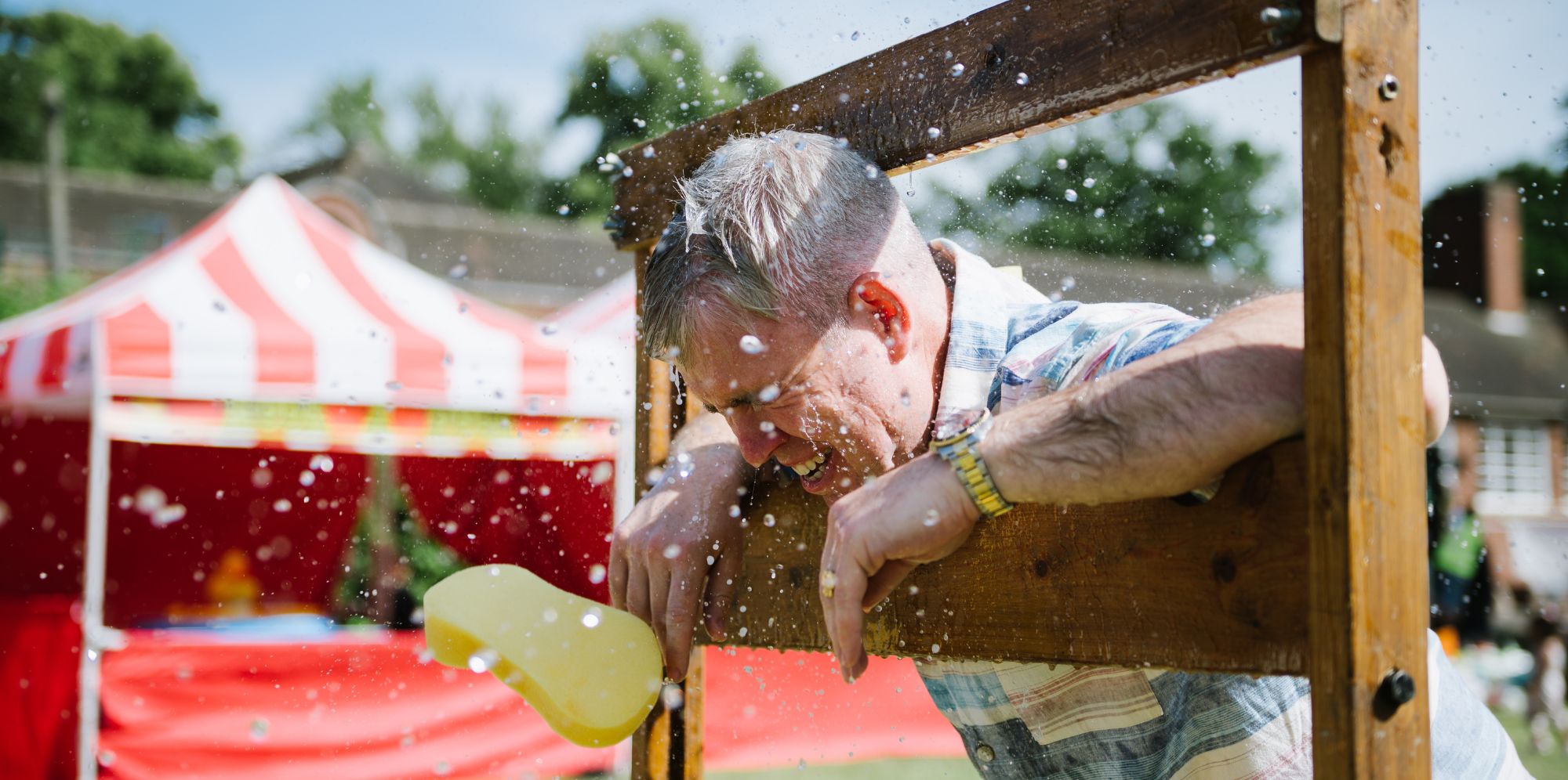 Man being hit with wet sponge on fun day.