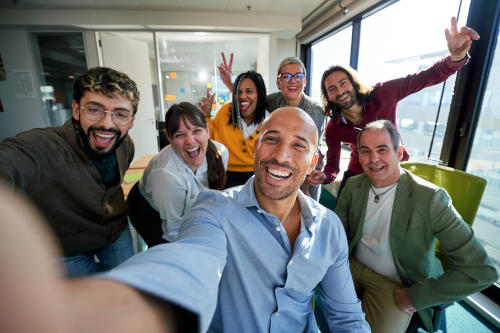 Happy business team taking a selfie in modern office together.